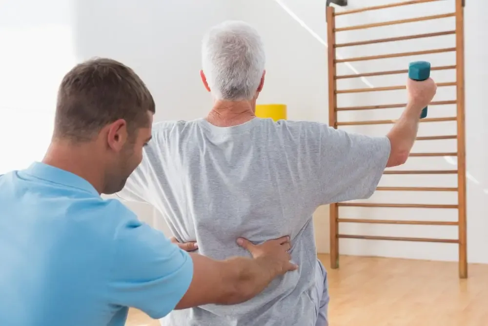 Physical therapist guiding an older adult through a supervised strengthening exercise